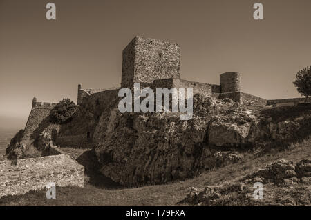 I muri di pietra e torri su una collina rocciosa con prato giardino e paesaggio di campagna a Marvao Castello. Un borgo medievale arroccato su una rupe in Portogallo. Foto Stock