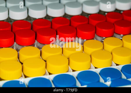 File di vasetti con coperchi multicolore. Concetto di medicina. Foto Stock