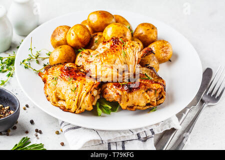 Pollo alla griglia e patate al forno in piastra bianca Foto Stock