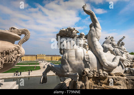 Schloss Schonbrunn, vista di un tritone a cavallo di un cavalluccio sulla Fontana di Nettuno con la Schloss Schönbrunn Palace in distanza, Vienna, Austria. Foto Stock