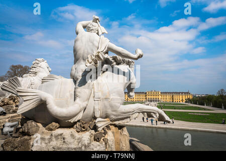 Palazzo Schonbrunn, vista di un tritone a cavallo di un cavalluccio sulla Fontana di Nettuno con la Schloss Schönbrunn Palace in distanza, Vienna, Austria. Foto Stock