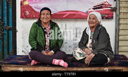 Coppie di donne Uyghur invecchiate che chiacchierano alla porta di casa-Hotan-Xinjiang-China-0115 Foto Stock