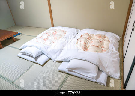 Futon; un giapponese materasso trapuntato laminati fuori sul pavimento (tatami) per uso come un letto., Giappone stile. Foto Stock