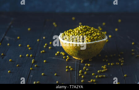 Ciotola con nucleasi vicino sul buio tavolo in legno con spazio di copia Foto Stock