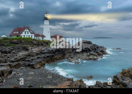 Faro luce fascio in nuvole temporalesche, Portland, Maine, Stati Uniti d'America. Foto Stock