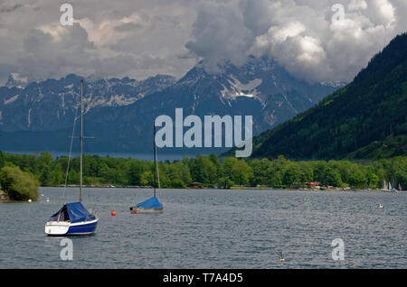 Ancorate barche a vela su Zeller (lago Zell) rivolti verso le montagne di fronte Zell am See in Austria Foto Stock