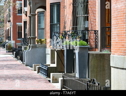 Boston South End per architettura. Mattone rosso marciapiede e fila facciate di case, ghisa recinzioni, griglie e balconi, entrata in pietra passi, giardino urna, sty Foto Stock