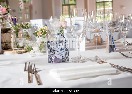 Una camera preparata per un matrimonio in un ristorante con tavoli ben stabiliti in bianco Foto Stock