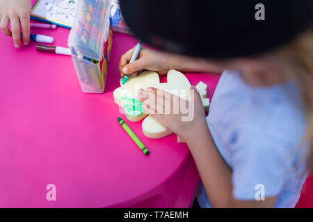 Bambino dipinge una rana verde con una matita Foto Stock