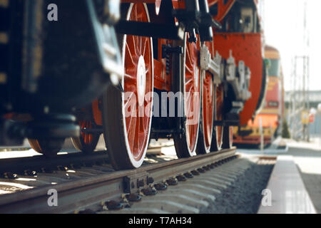 Le ruote della vecchia locomotiva pesante, dipinte di rosso e in piedi sulle rotaie che sono nel museo Foto Stock