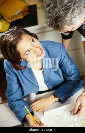 Maschio e femmina di colleghi di lavoro in un ufficio, STATI UNITI D'AMERICA Foto Stock