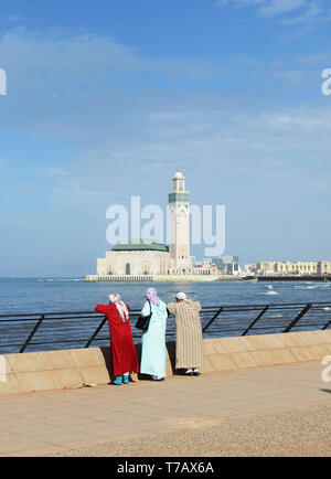 Local marocchini godendo la vista della Moschea di Hassan II a Casablanca. Foto Stock