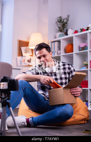 Dai capelli scuri blogger attento jeans blu durante le riprese Foto Stock