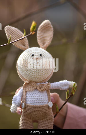 SYKTYVKAR, Russia - 05 Maggio 2019: immagine illustrativa. Coniglio a maglia giocattolo nella tecnica di maglieria amigurumi Foto Stock