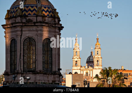 Il Santuario de la Virgen de Guadalupe con la cupola emisferica della Parroquia de Nuestra Señora de la Asunción chiesa in primo piano in Jalostotitlan, Stato di Jalisco, Messico. Foto Stock