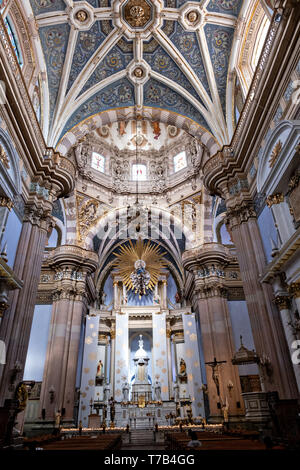 Gli ornati in stile barocco stile Churrigueresque interno della parrocchia di Nostra Signora dell'Assunzione chiesa localmente noto come Parroquia de la Asunción de Maria in Lagos de Moreno, Stato di Jalisco, Messico. Lo stile barocco chiesa parrocchiale è il più grande della città ed è stato costruito nel 1741 per la maggior parte di una pietra rosa locale noto come cantera rosa che dà alla Chiesa un colore rosa tinta. Foto Stock