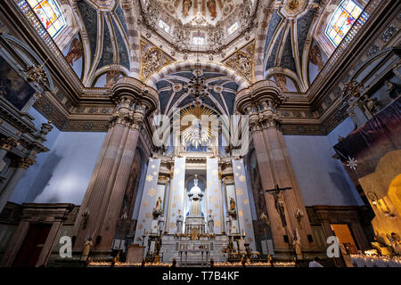 Gli ornati in stile barocco stile Churrigueresque interno della parrocchia di Nostra Signora dell'Assunzione chiesa localmente noto come Parroquia de la Asunción de Maria in Lagos de Moreno, Stato di Jalisco, Messico. Lo stile barocco chiesa parrocchiale è il più grande della città ed è stato costruito nel 1741 per la maggior parte di una pietra rosa locale noto come cantera rosa che dà alla Chiesa un colore rosa tinta. Foto Stock