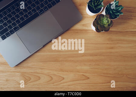 Laptop e succulenta in pentola impianto sul tavolo di legno vista dall'alto. Foto Stock