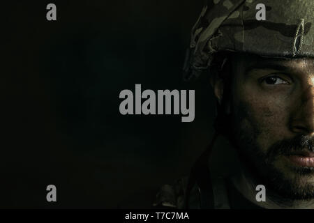 Lato Oscuro di me sarà sempre chiuso. Close up ritratto di Giovane Maschio soldato. Uomo in uniforme militare sulla guerra. Premuto e si verificano dei problemi con la salute mentale e le emozioni, PTSD, riabilitazione. Foto Stock
