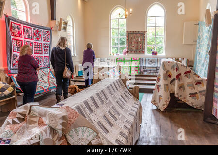 In casa trapunte sul display in un villaggio hall all'Oakhanger può Fayre in Hampshire, Regno Unito. Mostra di artigianato, cucito, ricamo, artigianato. Foto Stock