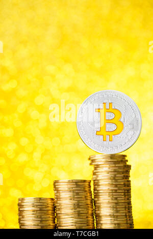 Bitcoin moneta con golden bitcoin simbolo sulla sommità della pila di monete scale con oro sfondo bokeh di fondo Foto Stock