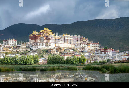 Songzanlin tibetano monastero buddista si riflette nel lago sacro, Shangri-La, nella provincia dello Yunnan in Cina Foto Stock