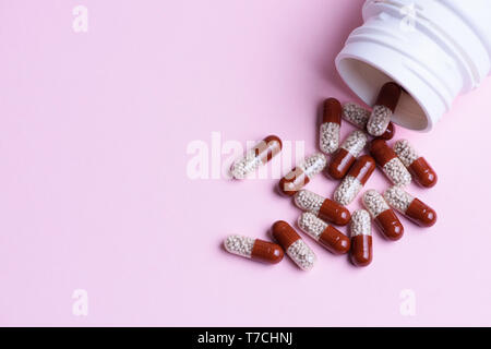 Pillole di trasparente e pillola bottiglia su sfondo blu Foto Stock