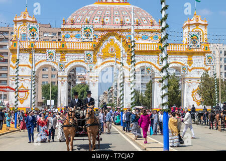 Siviglia, Spagna - 5 Maggio 2019: Gli Uomini su un carro trainato da cavalli nella parte anteriore della porta principale durante la fiera di Aprile di Siviglia il Maggio 5, 2019 a Siviglia, Spa Foto Stock