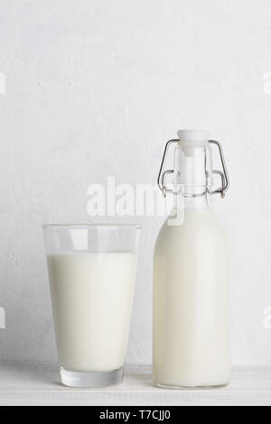 Vintage bottiglia di latte e un bicchiere di latte sul legno bianco sullo sfondo della tabella Foto Stock