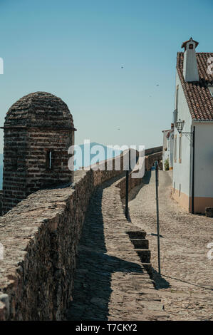 Parete spessa con percorso e torre di vedetta su di esso, nella parte anteriore del vecchio muro imbiancato la casa a Marvao. Un borgo medievale arroccato su una rupe in Portogallo. Foto Stock