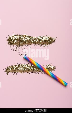 Shiny glitter linee con un arcobaleno lo sniffing di paglia di carta su sfondo color pastello. Parte il concetto di droghe. Foto Stock