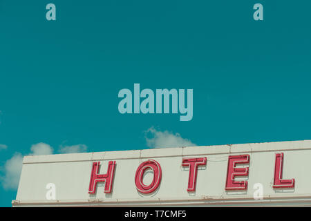 Hotel Vintage insegna al neon testo sul vecchio edificio con sky spazio copia a colori retrò stilizzata Foto Stock
