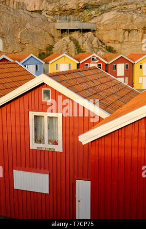 In maniera colorata di legno verniciato di pesca tradizionali capanne in barca / cabine in Smogen sulla costa di Bohuslan in Vastra Gotaland Svezia Foto Stock