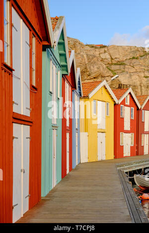 In maniera colorata di legno verniciato di pesca tradizionali capanne in barca / cabine in Smogen sulla costa di Bohuslan in Vastra Gotaland Svezia Foto Stock