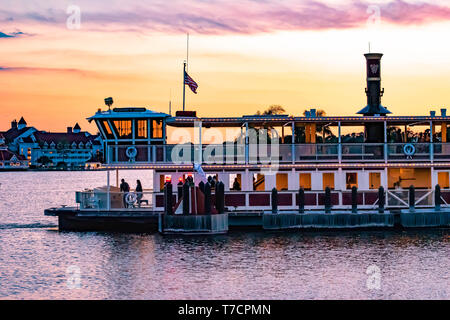 Orlando, Florida. Aprile 23, 2019. Disney ferry boat e vista parziale del Grand Floridian Resort & Spa su sfondo al tramonto presso il Walt Disney World area Foto Stock