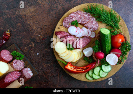 Fette di salame e verdure fresche su un vassoio in legno Snack vassoio. Vista dall'alto. Foto Stock