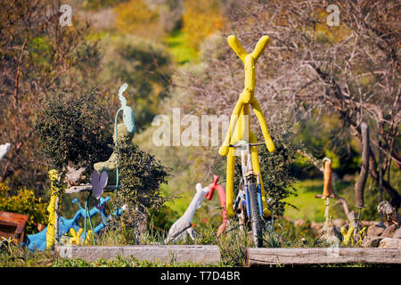 Bodrum, Turchia - Gennaio, 2019: Giallo deer scultura a cavallo di un arrugginito bici vintage in un parco per bambini. Abstract moderna arte pubblica per i bambini. Foto Stock