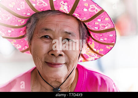 Bel volto ritratto di soft con gli occhi e un sorriso che indossa un cappello tradizionale, l'immagine è stata scattata nel mercato galleggiante di Amphawa Foto Stock