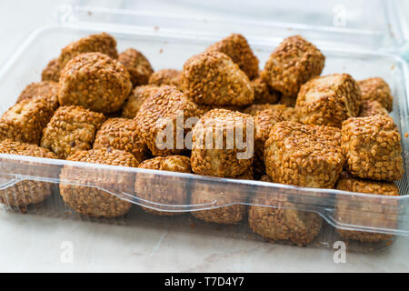 Turco pasticceria salata Bagel sfere Kahke Simit con semi di sesamo / snack salati in una tazza di plastica confezione o contenitore. I cibi tradizionali. Foto Stock