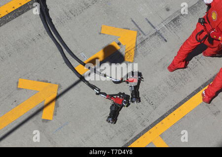 British Grand Prix 2018 meccanici Ferrari a piedi dalla buca dopo aver praticato una ruota cambia con le loro gambe e pistole a ruota in vista Foto Stock