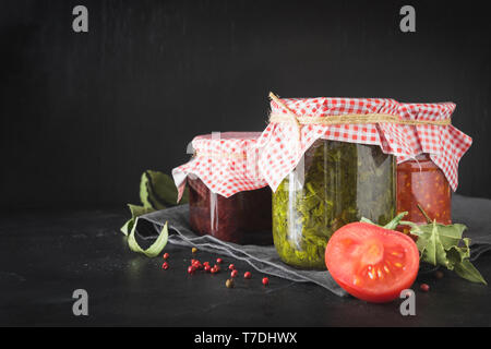 Vari tipi di conserve di salsa fatta in casa per servire alla carne, adjika dal pomodoro, sorrel, tkemali dalla prugna. Preparati in casa, compiti e traditi Foto Stock