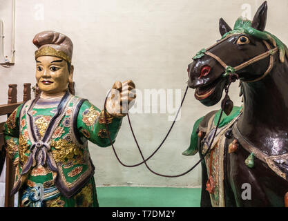 Hong Kong, Cina - 7 Marzo 2019: Tai O villaggio di pescatori. Primo piano di uomo con statua equestre a Kwan Tai tempio taoista. Foto Stock