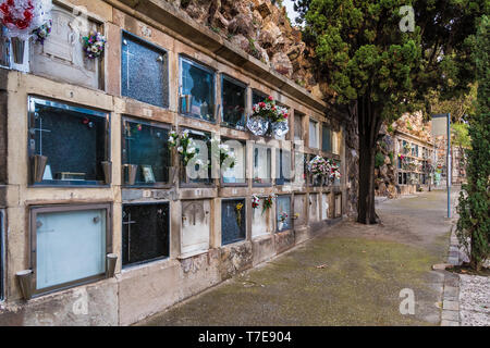 Vista prospettica del sentiero con tombe del cimitero di Montjuic nel giorno nuvoloso, Barcellona, in Catalogna, Spagna Foto Stock