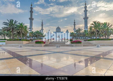 Vista assiale della Grande Moschea di Abu Dhabi alla fine del pomeriggio con pavimentazione luccicanti in primo piano, Regno emirato Arabo Foto Stock