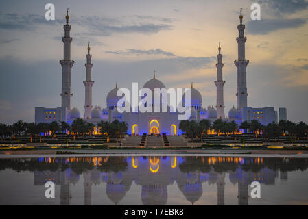 Vista assiale della Grande Moschea di Abu Dhabi al tramonto con la riflessione su un acqua, Regno emirato Arabo Foto Stock