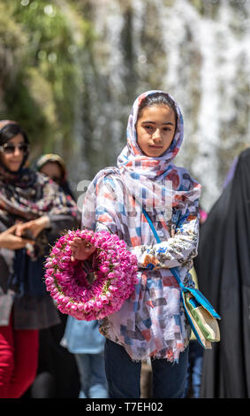 Niasar, Iran, 25 Aprile 2019: giovani iraniani la Dama con fiori, che li vendono per la passbyers durante la rosa stagione di raccolta Foto Stock