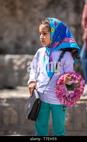 Niasar, Iran, 25 Aprile 2019: giovani iraniani la Dama con fiori, che li vendono per la passbyers durante la rosa stagione di raccolta Foto Stock