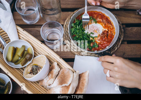 Shakshuka, uova fritte in salsa di pomodoro sulla tavola. Street Restaurant Foto Stock