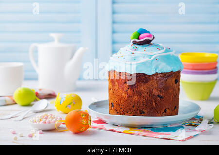 Torta di Pasqua con uova colorate. Bianco e blu sullo sfondo di legno. Spazio di copia Foto Stock