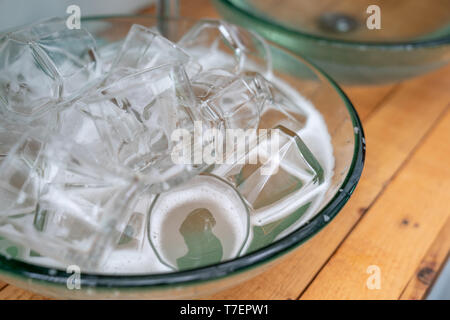 Un sacco di un bicchiere di vetro di acqua nel lavandino di vetro pronto per lavare e pulire. Foto Stock